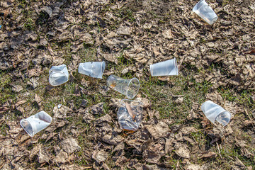 Plastic glasses polluting the environment. Environmental disaster.