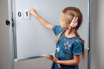 Fototapeta na wymiar Pretty adorable sharming child arranging numbers in the correct order. Beautiful child holding a card with number 1. Concept of numerals. photo with noise.