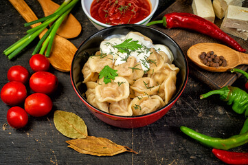 Russian dumplings with sour cream in a bowl, top view