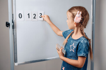 Portrait of a smart intelligent child arranging numbers in the correct order. Beautiful child...