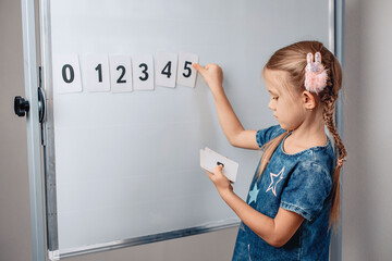 Portrait of intelligent lovely smart kid arranging numbers in the correct order. Lovely child...