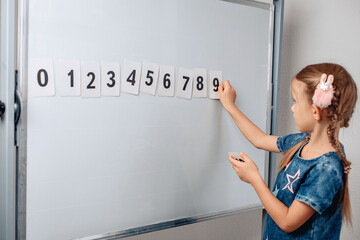 Portrait of a sharming little pretty child arranging numbers in the correct order. Lovely child...