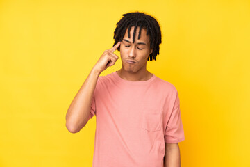 Young african american man isolated on yellow background making the gesture of madness putting...