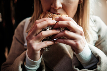 Woman eating hamburger. Fast food concept. Mouth close up.