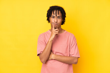 Young african american man isolated on yellow background and looking front