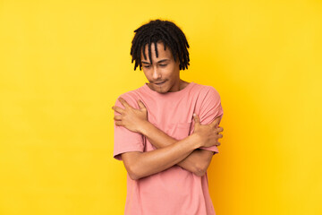 Young african american man isolated on yellow background freezing