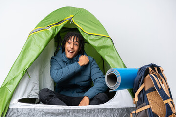 Young african american man inside a camping green tent celebrating a victory