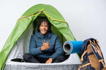 Young african american man inside a camping green tent giving a thumbs up gesture