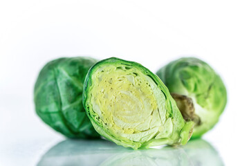 A half Brussel sprout with green sprouts on a white background, close up, isolated