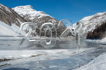Transparent glass number 2021 in winter mountains on New Year.