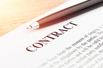 Legal contract signing - buy sell real estate contract. Pen lying on a contract or application form. Close up.