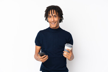 Young african american man isolated on white background holding coffee to take away and a mobile