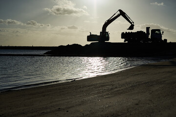 ビーチの護岸工事　ショベルカーとダンプカー © okioki