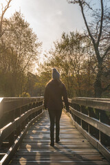 Woman walking across bridge autumn