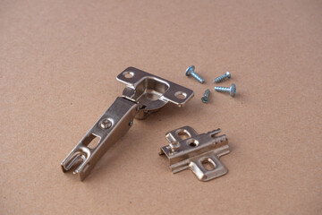Metal furniture and kitchen cabinet hinges lays on cartboard