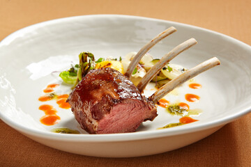 Rack of lamb in white deep plate close-up