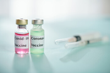 Two vials with different kinds of vaccine against coronavirus and syringes