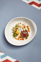 Rack of lamb in white deep plate top view