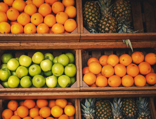 Green apples, tangerines and pineapples on wood counter fruit background and texture