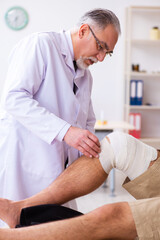 Obraz premium Experienced doctor traumatologist examining young male patient