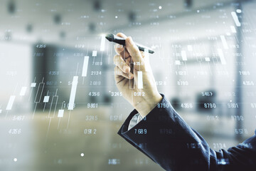 Double exposure of male hand with pen working with abstract creative statistics data hologram on blurred office background, analytics and forecasting concept