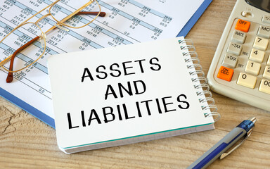 Asset and Liability is written on a notepad on an office desk