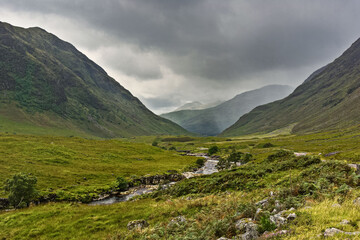 Glen Etive, a remote valley in the mountains near Glencoe in the Highlands of Scotland, where the River Etive flows between banks lined with heather and bracken.
