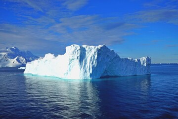 This iceberg floats on the sea. Some parts of the iceberg are too bright in the sun.
