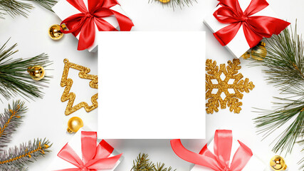 Christmas composition. White gift box with red ribbon, New Year balls and Christmas tree in xmas composition on white background for greeting card. Flat lay, top view, copy space.