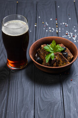 Grilled pork ribs with fresh parsley ,damson and glass of dark beer on black wooden background