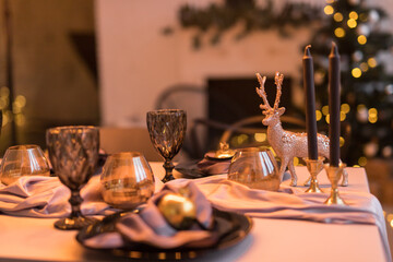 Close up of festive Christmas table setting with empty wine glasses and black plate