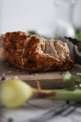 
The prepared indica breast lies on a tree board. Vegetables and peppers and salt are lying around.