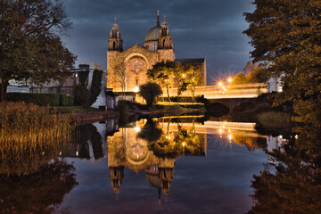 Obraz premium Galway cathedral by the Corrib River at night with reflection in water in Ireland 