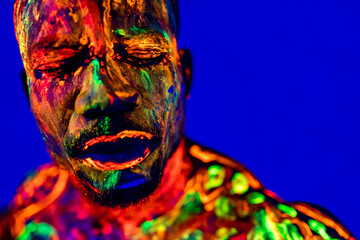 afro american man with UV body art posing in studio