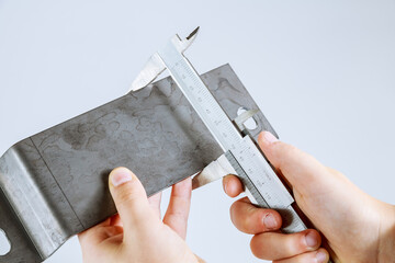 precise measurement of metal parts on a white background using a vernier caliper
