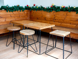 Empty wooden table and wooden chairs with Christmas ornament object decorations.