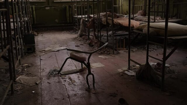 Baby cots and children bicycle in an abandoned kindergarten in the ghost town Pripyat in the Chernobyl exclusion zone in Ukraine 2020