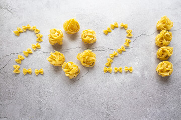 The figures 2021 from shells, bows are laid out from pasta