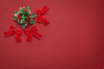 red christmas background with new year decor, bows and wreath  in the top left corner, free space for text,  mock up for design