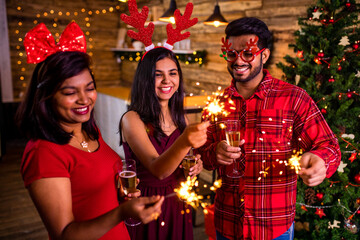 arabian people celebrating Christmas or New Year eve party with Bengal lights ooking happy while having party on the kitchen at stay home quarantine corona virus outbreak party
