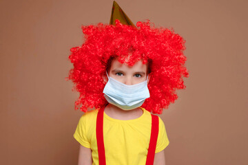 Medical mask on a clown girl. Ban on celebrations and performances.