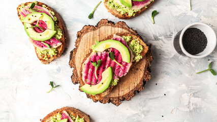 Healthy breakfast toasts from sliced watermelon radish and avocado. banner, catering menu recipe place for text, top view