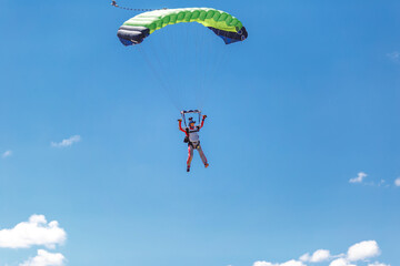 skydiving in the clouds. colorful parachute on the blue sky background