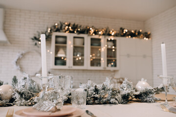 The large spacious kitchen is decorated for the New Year holidays. Table setting for the New Year. Christmas background