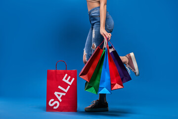 .Girl holding bags for sale on a blue background