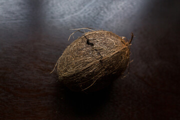 cracked coconut lies on a dark table