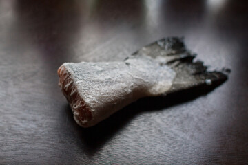 frozen salmon tail on a dark kitchen table