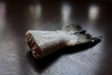 Fototapeta na wymiar frozen salmon tail on a dark kitchen table
