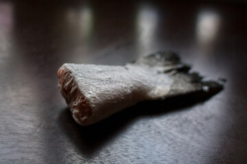 frozen salmon tail on a dark kitchen table