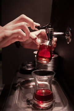 Cropped Hands Of Man Filling Water In Glass At Darkroom